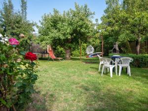 a group of chairs and a swing in a yard at Holiday Home Parkowa by Interhome in Koszalin