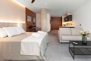 Habitación de hotel con cama y sala de estar. en Calatrava by Alma Suites, en Valencia