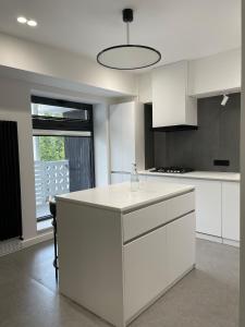 Una cocina con gabinetes blancos y una encimera blanca. en Fresh central apartment, en Tashkent