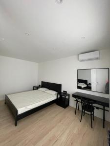 Un dormitorio con una cama, un escritorio y un espejo. en Fresh central apartment, en Tashkent