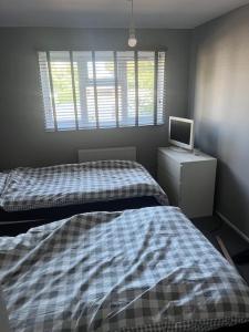 1 dormitorio con 2 camas y un ordenador en un escritorio en Chilled space that sleeps upto 4, en Barking