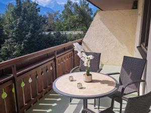 a table and chairs on a balcony with a table at Apartment Kitzblick by Interhome in Zell am See