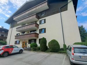 a building with two cars parked in front of it at Apartment Kitzblick by Interhome in Zell am See