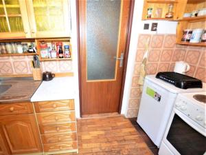 a small kitchen with a stove and a door at Holiday Home Jahor by Interhome in Splzov