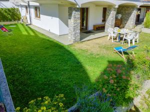 un jardín con mesa y sillas en un patio en Apartment Résidence La Fenière 03 by Interhome, en Crans-Montana