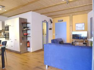 un soggiorno con divano blu e una cucina di Apartment Tilia by Interhome a Bönigen