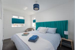 a bedroom with a large bed with a green curtain at Seaweed in Combe Martin