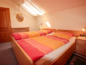 sypialnia z 2 łóżkami z pomarańczowymi i żółtymi kocami w obiekcie Apartment Alex Top 68 by Interhome w mieście Bad Hofgastein