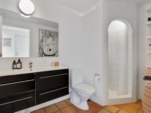 a bathroom with a toilet and a sink and a mirror at Apartment Virpi - 1km from the sea in NW Jutland by Interhome in Blokhus
