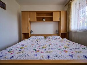 um quarto com uma cama com um edredão floral em Apartment Špičák II by Interhome em Albrechtice v Jizerskych horách