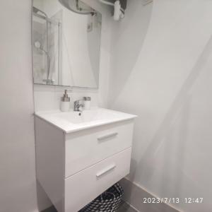 uma casa de banho branca com um lavatório e um espelho em Appartement quai de Joliette/ mucem/major em Marselha