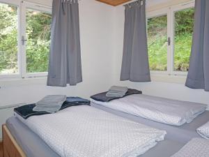 two twin beds in a room with windows at Chalet Lieblingsplatz by Interhome in Flirsch