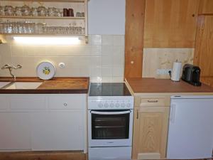 a kitchen with a white stove top oven next to a sink at Chalet Lieblingsplatz by Interhome in Flirsch