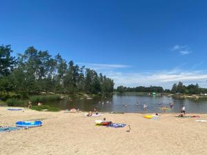 grupa ludzi pływających w wodzie na plaży w obiekcie Holiday Home Kemp Stříbrný rybník-3 by Interhome w mieście Hradec Králové