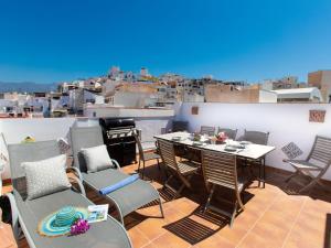 un balcon avec tables et chaises et vue sur la ville dans l'établissement Holiday Home Marit by Interhome, à Almuñécar