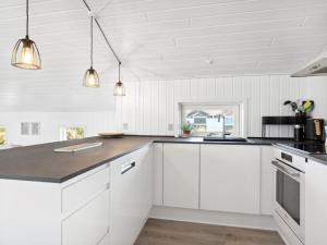 een keuken met witte kasten en een aanrecht bij Holiday Home Blaguna - 600m from the sea in NW Jutland by Interhome in Torsted