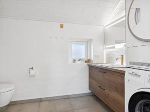 een witte badkamer met een toilet en een wastafel bij Holiday Home Blaguna - 600m from the sea in NW Jutland by Interhome in Torsted
