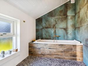 uma casa de banho com uma banheira e uma janela em Holiday Home Blaguna - 600m from the sea in NW Jutland by Interhome em Torsted