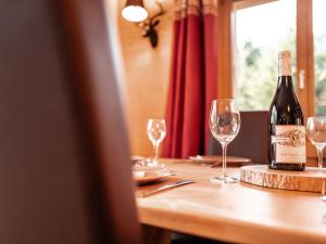 eine Flasche Wein auf einem Tisch mit Brille in der Unterkunft Chalet Dipankar by Interhome in Villars-sur-Ollon