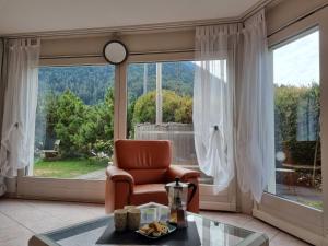 sala de estar con silla y ventana grande en Holiday Home Le Chant de la Dranse by Interhome, en Sembrancher
