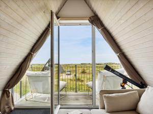 een woonkamer met een glazen deur naar een balkon bij Holiday Home Pauli - 350m from the sea in NW Jutland by Interhome in Pandrup