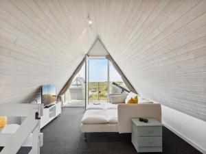 een witte kamer met een bank en een groot raam bij Holiday Home Pauli - 350m from the sea in NW Jutland by Interhome in Pandrup