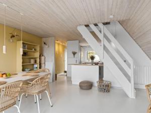 een woonkamer met een tafel en stoelen en een trap bij Holiday Home Pauli - 350m from the sea in NW Jutland by Interhome in Pandrup
