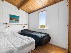 Schlafzimmer mit einem Bett und einem Fenster in der Unterkunft Holiday Home Satu - 500m from the sea in NW Jutland by Interhome in Torsted