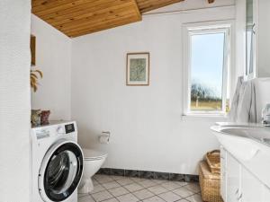 ein weißes Bad mit einer Waschmaschine in der Unterkunft Holiday Home Satu - 500m from the sea in NW Jutland by Interhome in Torsted