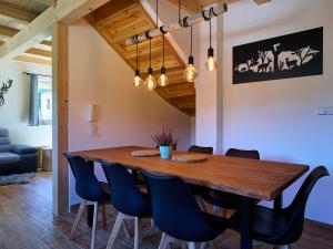 une salle à manger avec une table en bois et des chaises bleues dans l'établissement Holiday Home Muhu by Interhome, à Smržovka