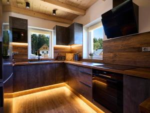 une cuisine avec des placards en bois et une grande fenêtre dans l'établissement Holiday Home Muhu by Interhome, à Smržovka