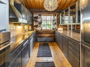 a kitchen with stainless steel cabinets and a chandelier at Holiday Home Villihanhi by Interhome in Kuusamo +24 photos