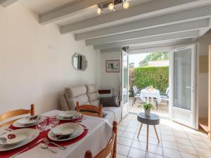 ein Esszimmer mit einem Tisch und ein Wohnzimmer in der Unterkunft Holiday Home Les Jardins de la Palmyre-2 by Interhome in Les Mathes