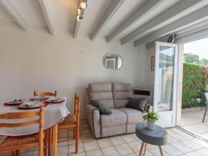 a living room with a table and a couch at Holiday Home Les Jardins de la Palmyre-2 by Interhome in Les Mathes