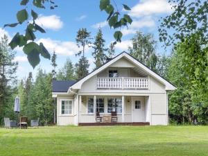 a white house with a porch and a deck at Holiday Home Villa vuorso by Interhome in Raanujärvi