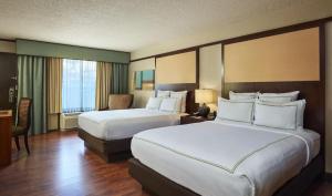 a hotel room with two beds and a desk at DoubleTree by Hilton Orlando Theme Park Resort in Orlando