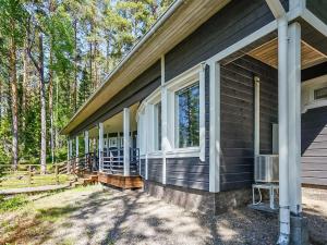 un porche delantero de una casa con árboles en Holiday Home Aurinkokaari by Interhome, en Heinävesi