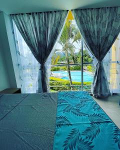 um quarto com uma cama e vista para uma piscina em FINCA HOTEL EL ENSUEÑO em Ibagué