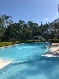 a swimming pool with a fountain in the middle at FINCA HOTEL EL ENSUEÑO in Ibagué