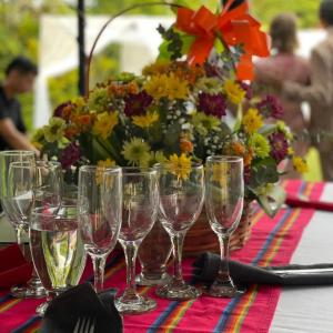 a table with wine glasses and a vase of flowers at FINCA HOTEL EL ENSUEÑO in Ibagué