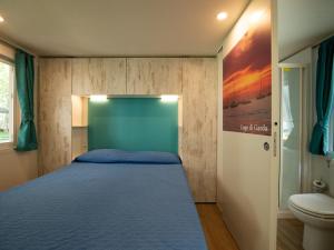 a small bedroom with a bed and a toilet at Holiday Home Garda Blue by Interhome in Rivoltella