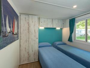 a bedroom with two beds and a window at Holiday Home San Francesco Camping Village by Interhome in Rivoltella