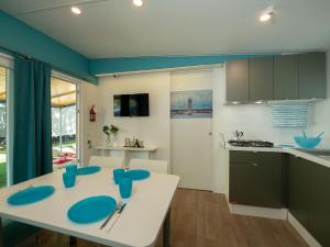 a kitchen with a white table and blue chairs at Holiday Home Garda Blue by Interhome in Rivoltella