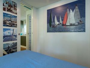 a bedroom with a picture of sailboats on the wall at Holiday Home Garda Blue by Interhome in Rivoltella +10 photos