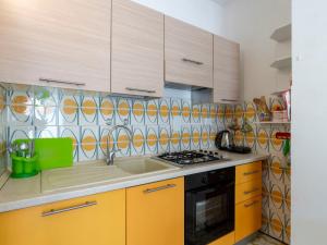 聖托·斯特凡諾·阿爾馬爾的住宿－Apartment Marisa by Interhome，厨房配有黄色橱柜和炉灶。