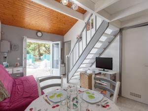 un soggiorno con un tavolo e una TV di Holiday Home Les Maisons de l'Océan-2 by Interhome a Les Mathes Altre 20 foto
