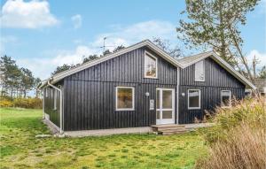 エーベルトフトにあるAwesome Home In Ebeltoft With 5 Bedrooms And Saunaの草原黒家