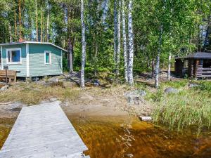 una cabaña en el bosque junto a un cuerpo de agua en Holiday Home Itälahti by Interhome, en Ihamaniemi