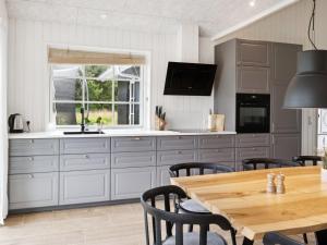 eine Küche mit Holztisch und ein Esszimmer in der Unterkunft Holiday Home Bryngeir - 750m from the sea by Interhome in Brøndstrup