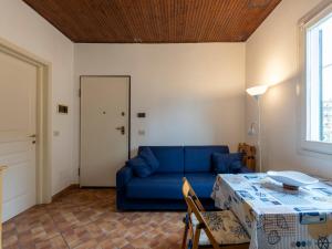 a living room with a blue couch and a table at Holiday Home Calderina by Interhome in Imperia